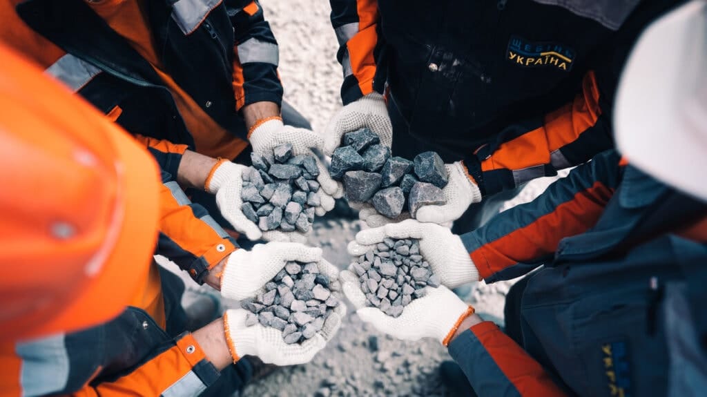 Працівники TBG римають різні фракції щебеню в руках